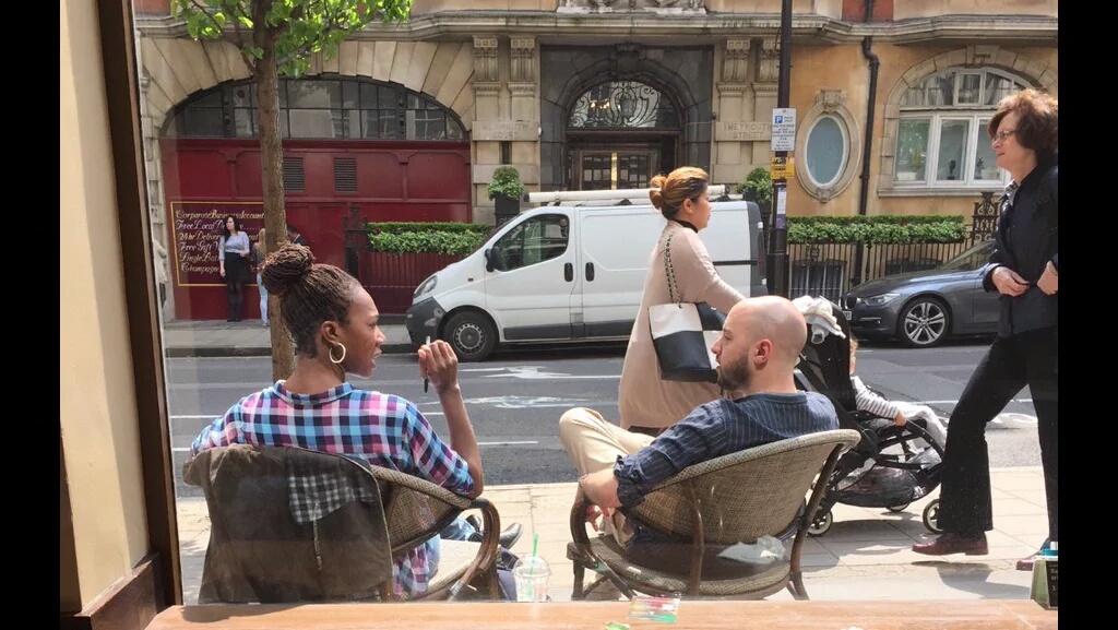 Woman and man sitting outside a cafe speaking